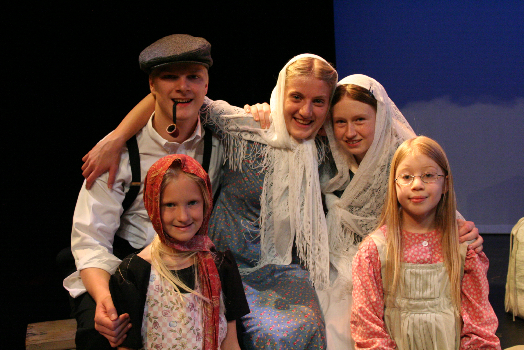 Five young actors in costume portraying a father, mother, and three daughters coming to Ellis Island in 1908.