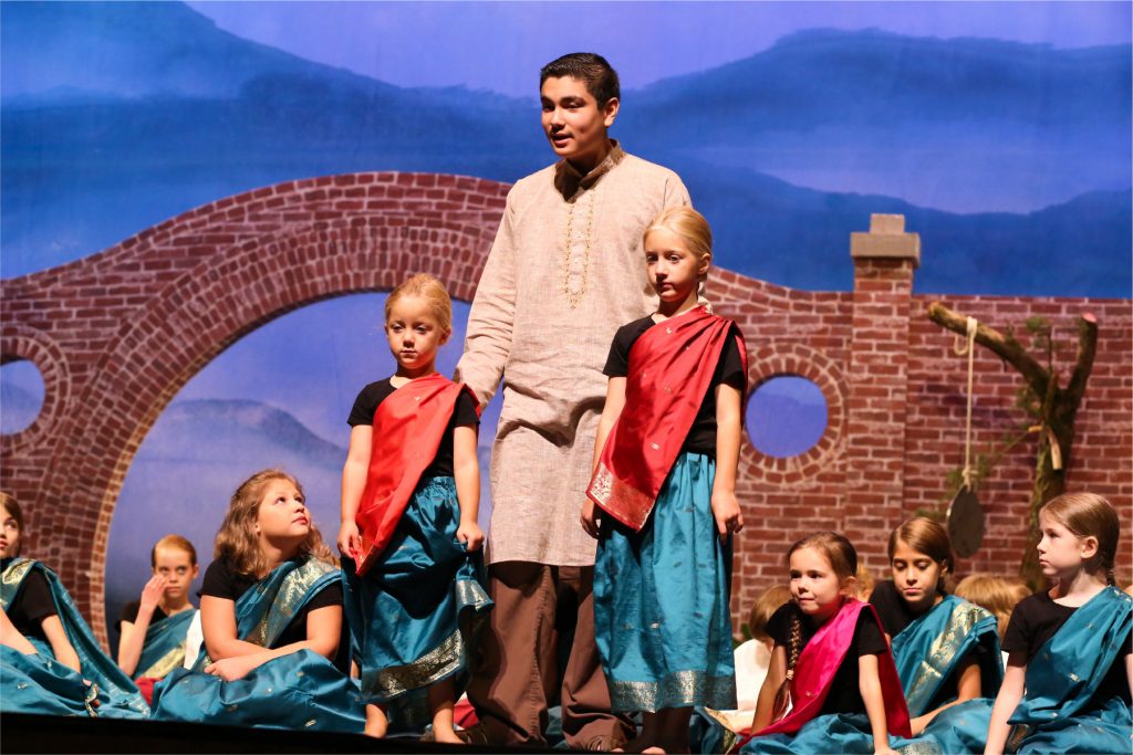 A group of young actors and actresses performing a scene in a play about Amy Carmichael in India