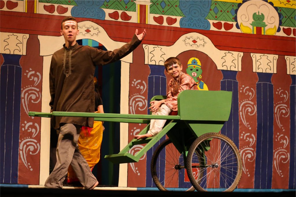 Two young actors performing a scene in a play set in China