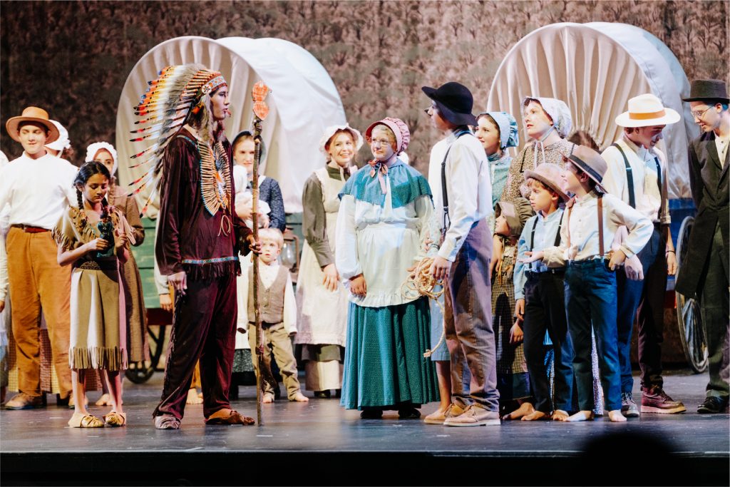 Young actors and actresses performing a play about life on the Oregon Trail